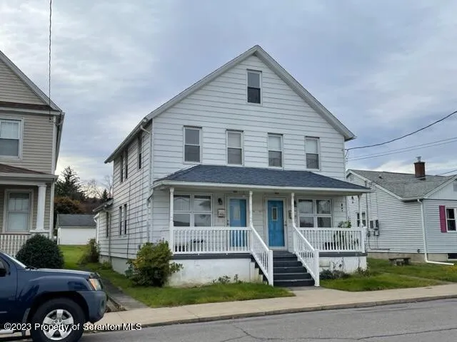 a front view of a house with a garden and plants