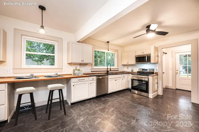a kitchen with granite countertop white cabinets a sink dishwasher and a stove