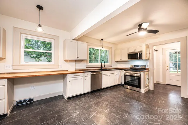 a large kitchen with granite countertop a stove and a sink