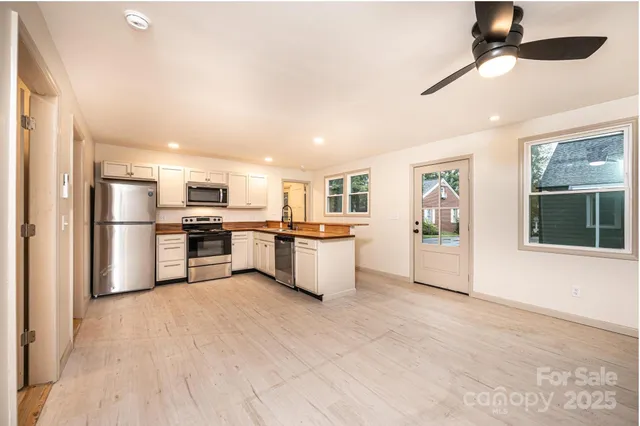 an empty room with fireplace and fan