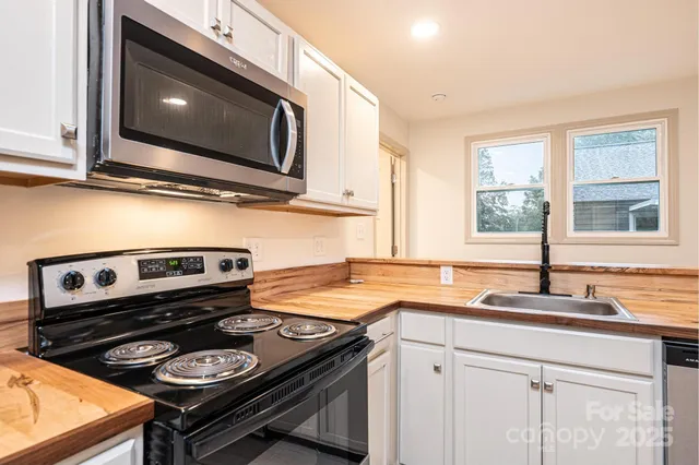 a kitchen with granite countertop stainless steel appliances and refrigerator