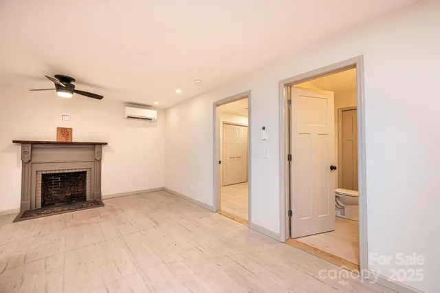 an empty room with a fireplace and windows