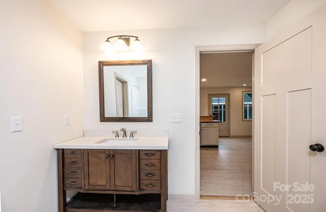 an empty room with wooden floor ceiling fan and windows