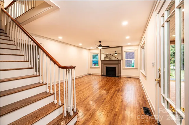 a view of a living room with wooden floor and fireplace