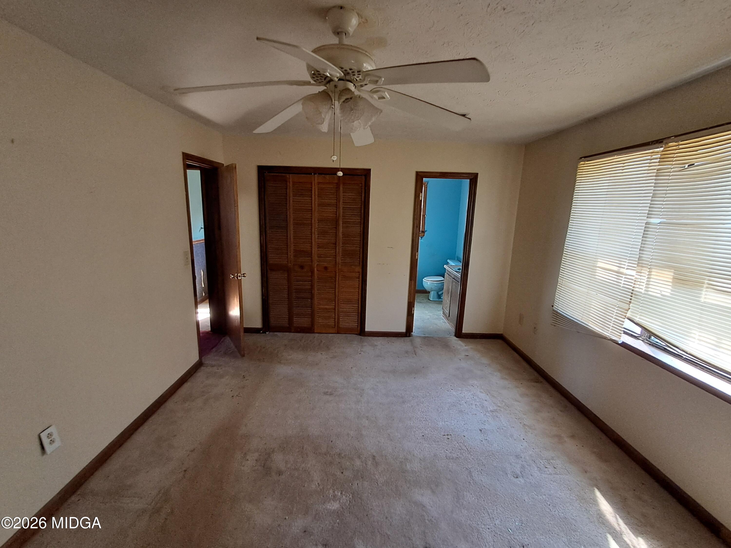 110 Irwinton Road Toomsboro, GA 31090 - Photo 12 of 17 an empty room with windows and fan