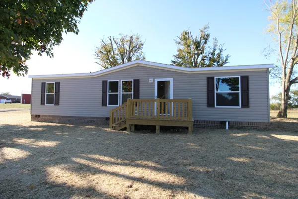 a view of a house with a yard and wooden fence