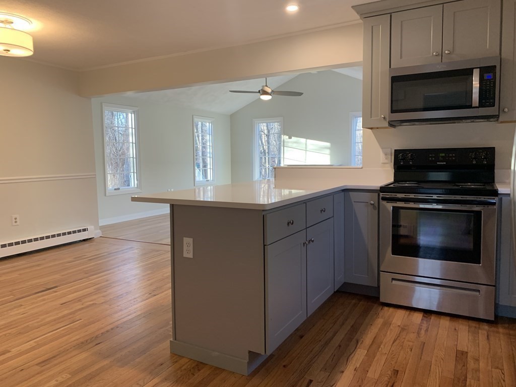7 Oregon Road Ashland, MA 01721 - Photo 6 of 27 a kitchen with granite countertop wooden floors and stainless steel appliances