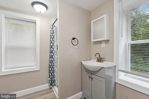 a bathroom with a sink a mirror and a window