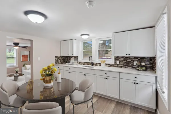 a kitchen with stainless steel appliances granite countertop a white cabinets and chairs
