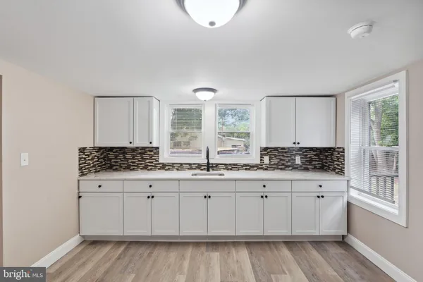 a kitchen with a sink a stove cabinets and wooden floor