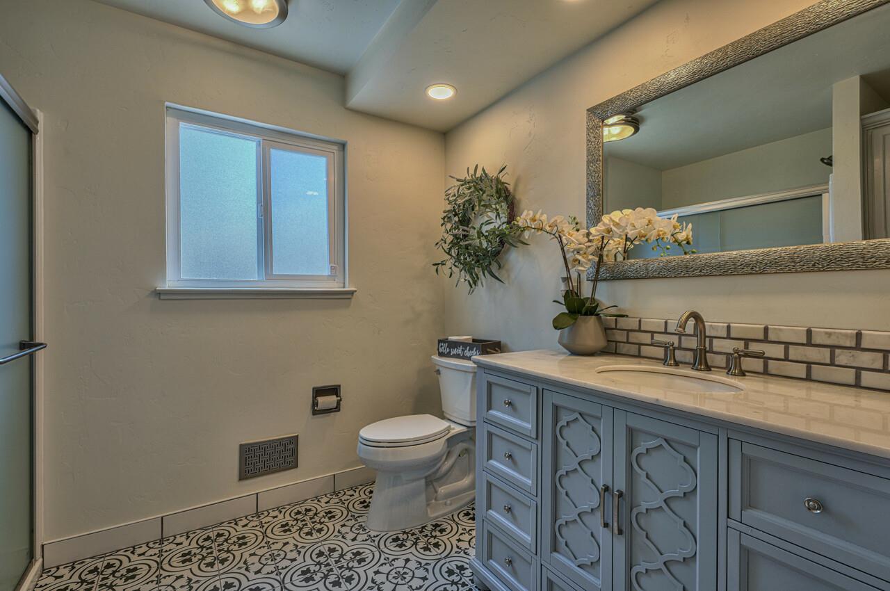 9859 Brookgrass Place Prunedale, CA 93907 - Photo 19 of 39 a bathroom with a granite countertop sink a toilet and a mirror