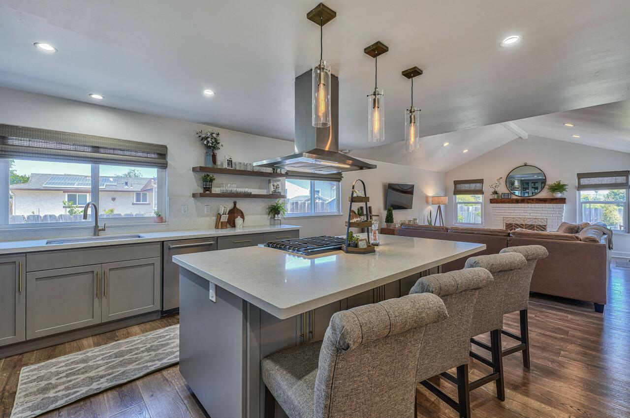 9859 Brookgrass Place Prunedale, CA 93907 - Photo 9 of 39 a kitchen with stainless steel appliances granite countertop a stove a sink a dining table and chairs with wooden floor