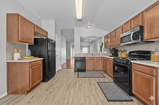 a kitchen with stainless steel appliances a refrigerator sink and cabinets