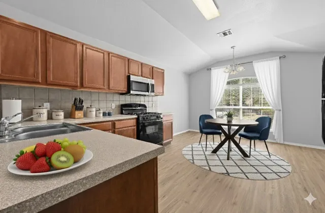 a kitchen with a sink a stove and a microwave