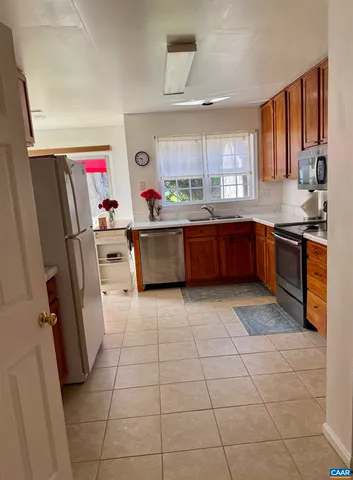 a kitchen with stainless steel appliances granite countertop a refrigerator stove top oven and a sink