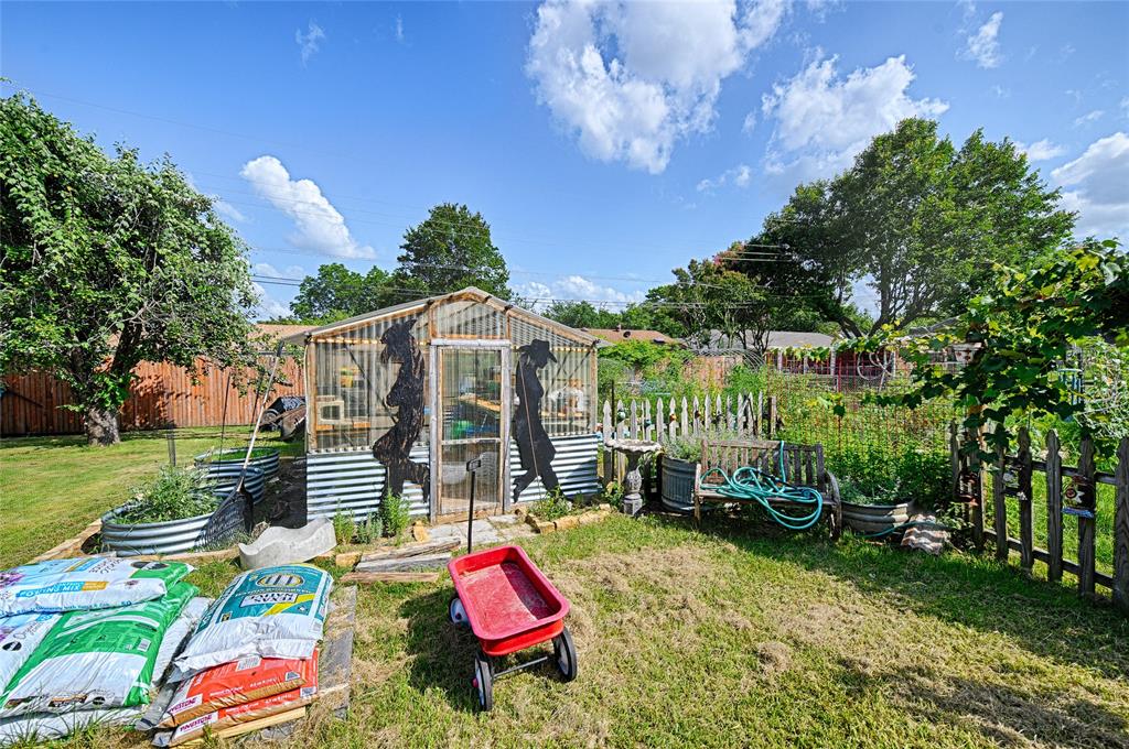 205 West Stark Road Seagoville, TX 75159 - Photo 22 of 39 a backyard of a house with table and chairs plants and large trees