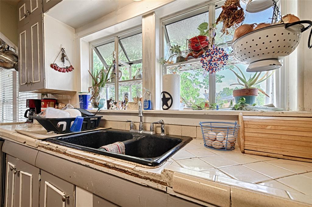 205 West Stark Road Seagoville, TX 75159 - Photo 8 of 39 a kitchen sink with granite countertop a stove a mirror and next to a window