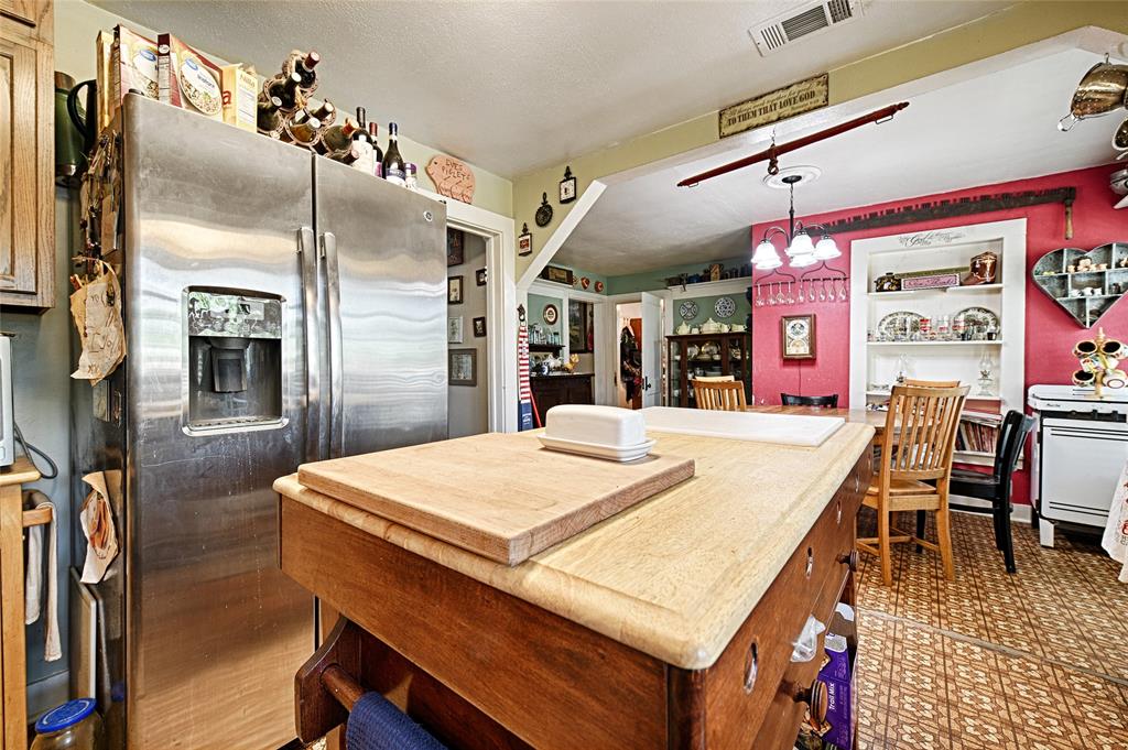 205 West Stark Road Seagoville, TX 75159 - Photo 9 of 39 a kitchen with stainless steel appliances kitchen island granite countertop a refrigerator a stove and a dining table with wooden floor
