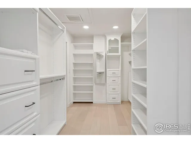a view of walk in closet with empty racks