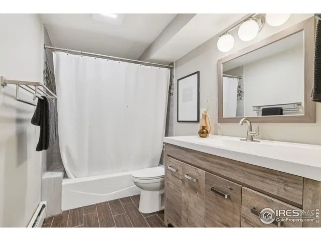 a bathroom with a sink a toilet a mirror and shower