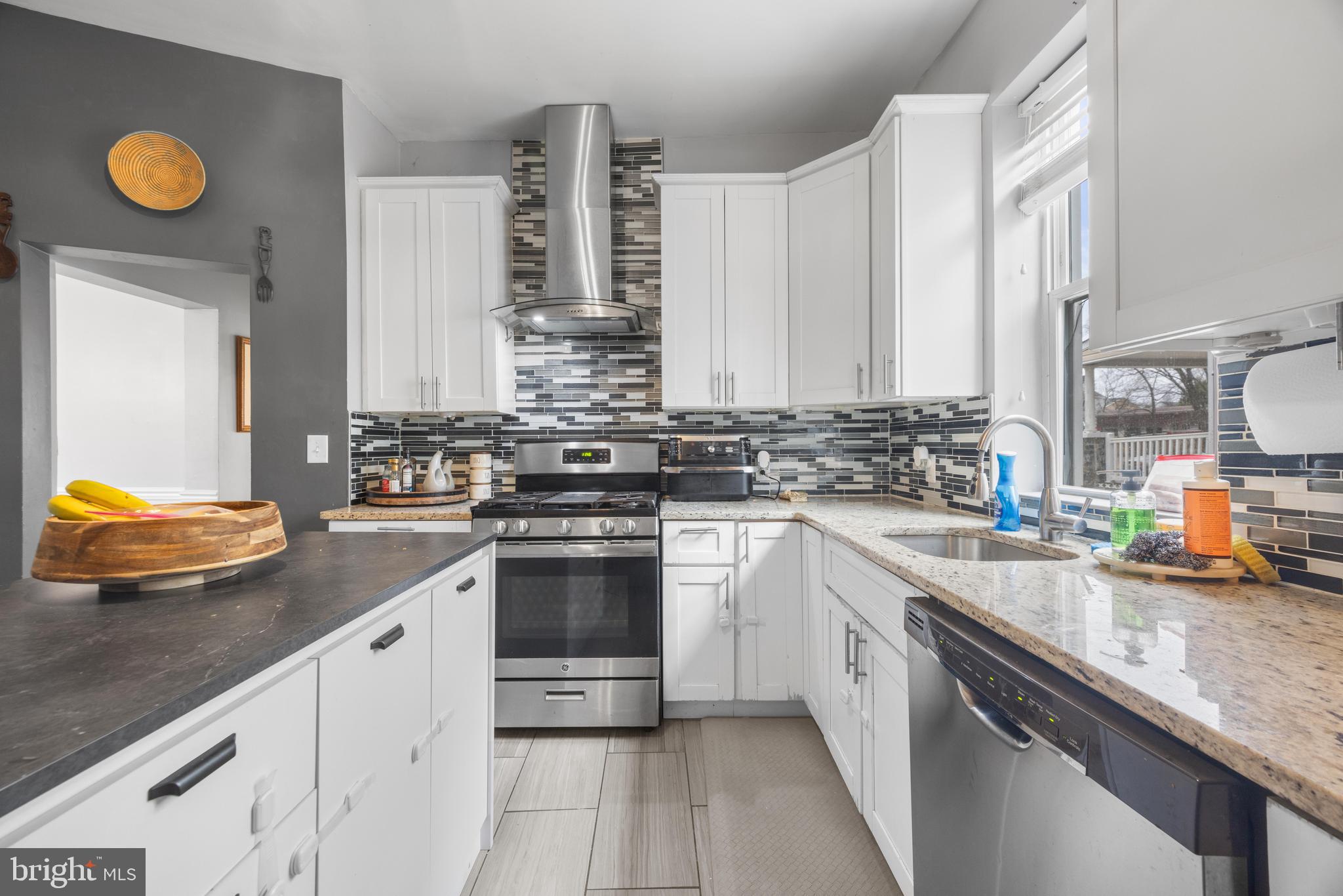 3814 Chatham Road Baltimore, MD 21215 - Photo 13 of 45 a kitchen with stainless steel appliances granite countertop a sink a stove cabinets counter space and a window