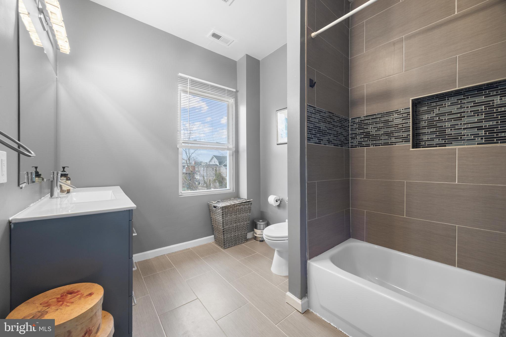 3814 Chatham Road Baltimore, MD 21215 - Photo 22 of 45 a bathroom with a sink a toilet and shower