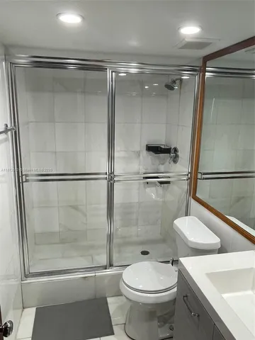 a bathroom with a sink mirror toilet and shower