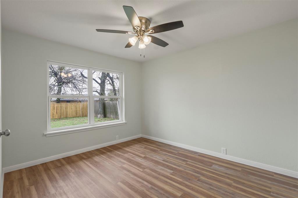 732 Bullock Street Denison, TX 75020 - Photo 19 of 29 a view of an empty room with wooden floor and a window