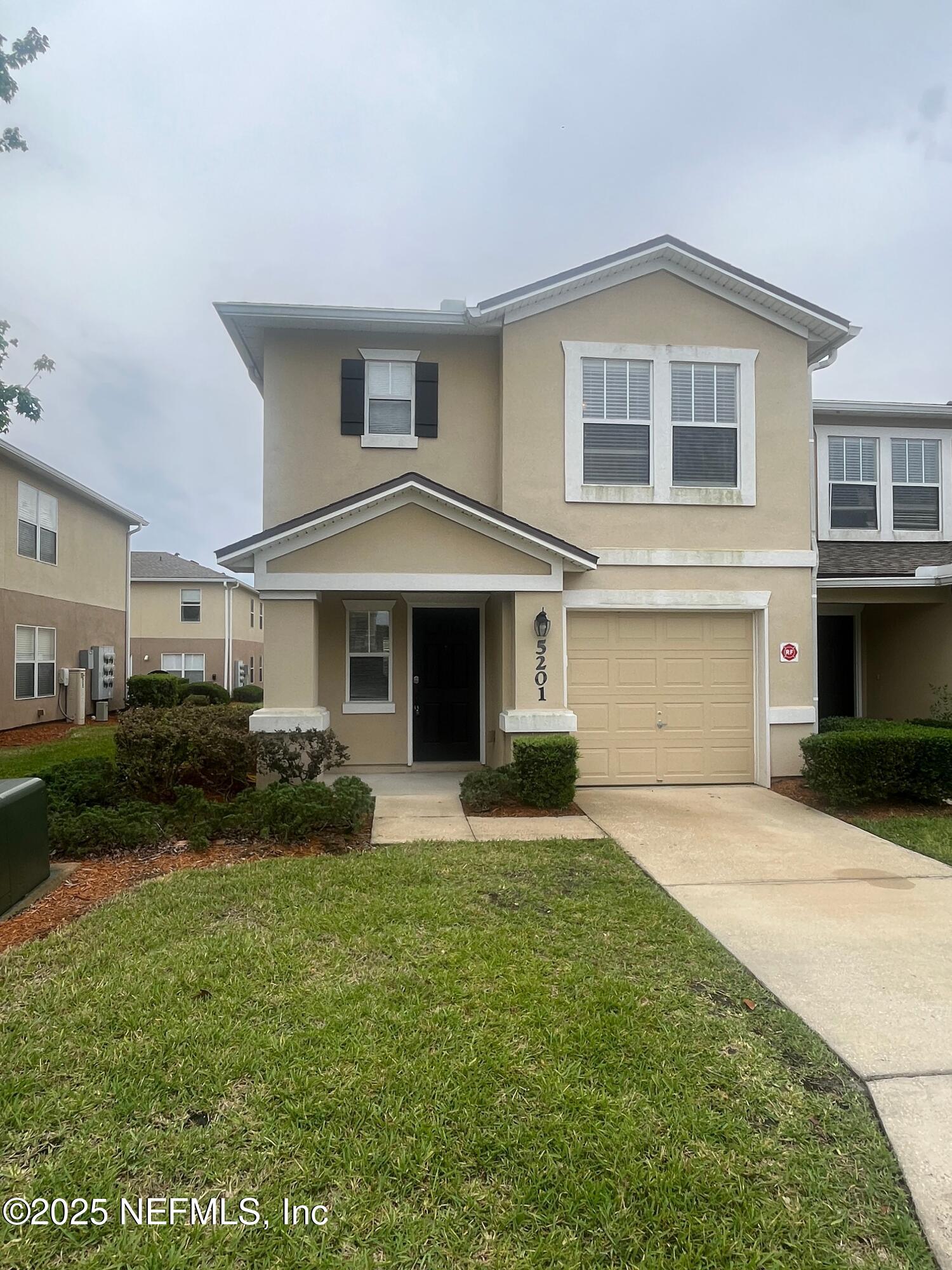 1500 Calming Water Drive, Unit 5201 Fleming Island, FL 32003 - Photo 1 of 39 a front view of a house with a yard and garage