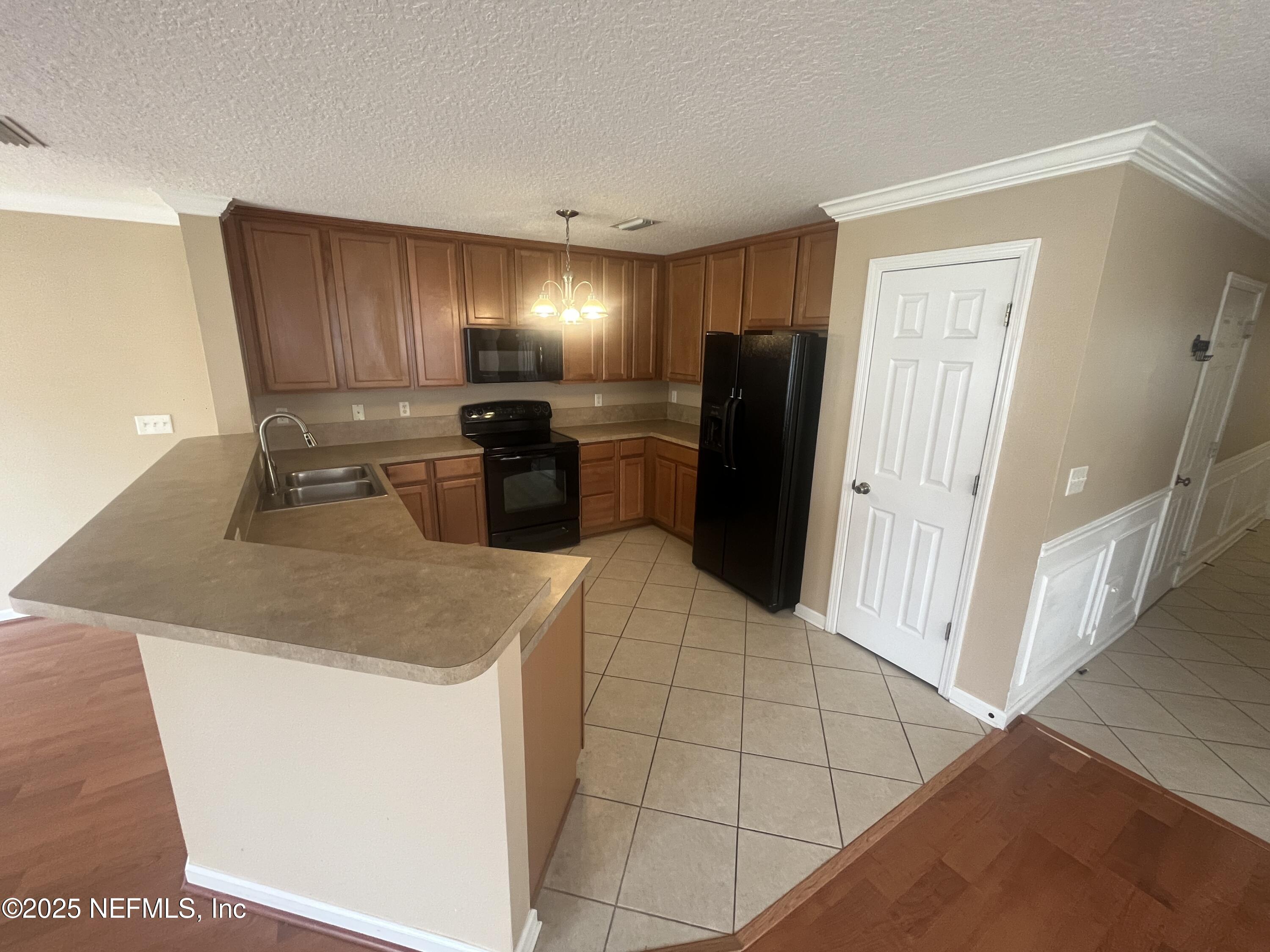 1500 Calming Water Drive, Unit 5201 Fleming Island, FL 32003 - Photo 13 of 39 a kitchen with a sink and refrigerator