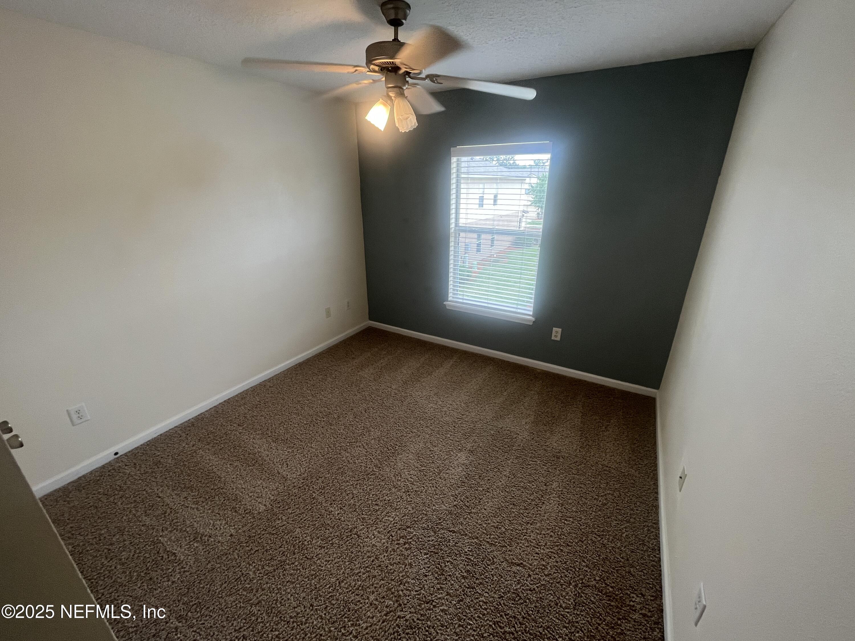 1500 Calming Water Drive, Unit 5201 Fleming Island, FL 32003 - Photo 18 of 39 an empty room with windows and fan