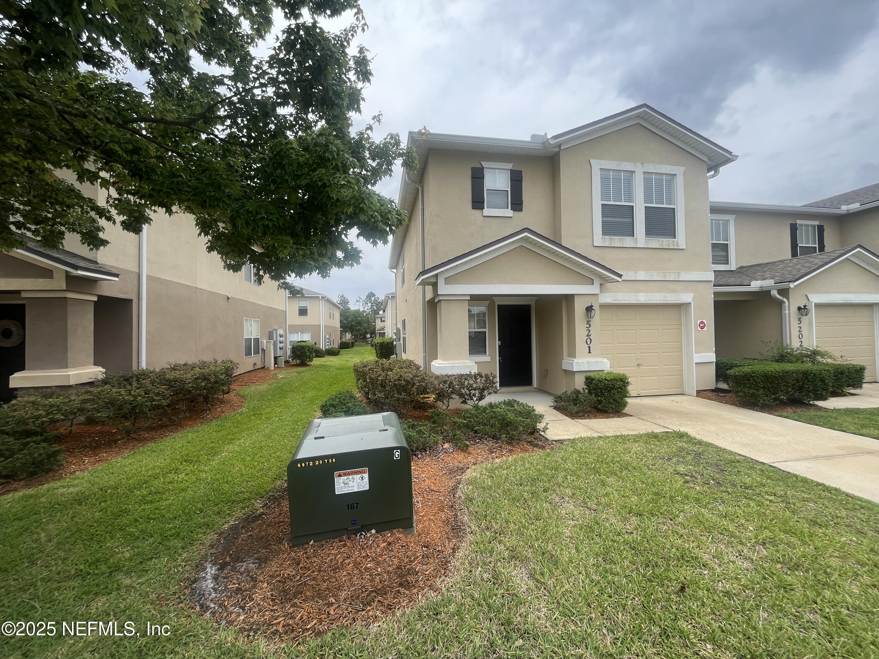 1500 Calming Water Drive, Unit 5201 Fleming Island, FL 32003 - Photo 3 of 39 a front view of a house with a yard and porch