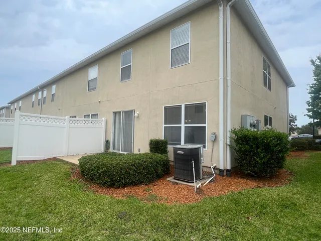 a front view of a house with garage and plants