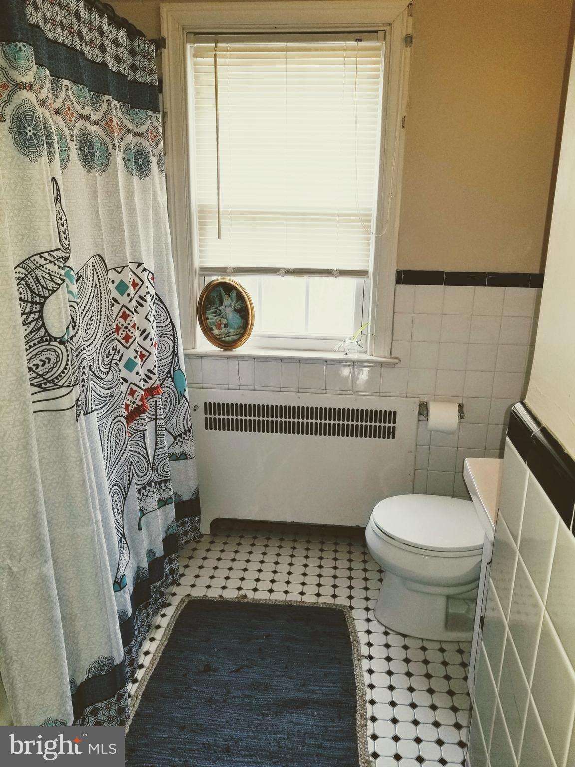 211 Ridley Drive Wallingford, PA 19086 - Photo 9 of 12 a bathroom with a toilet and a shower curtain