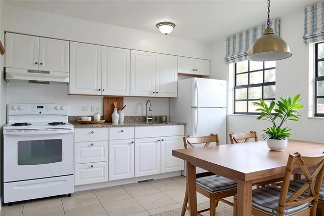 a kitchen with white cabinets and white appliances