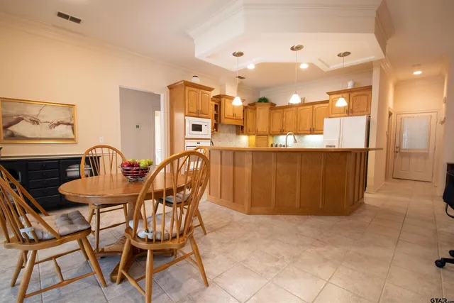 a dining area with a table chairs and a kitchen view