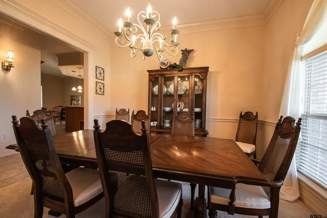 a view of a dining room with furniture and chandelier