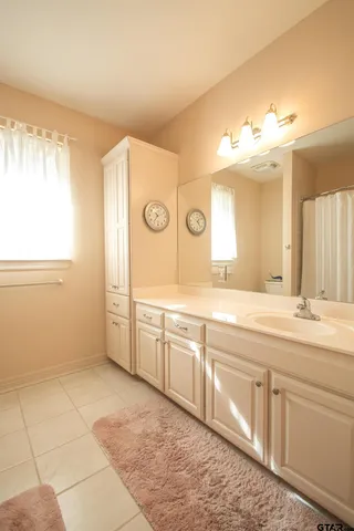 a spacious bathroom with a sink a mirror and a bathtub