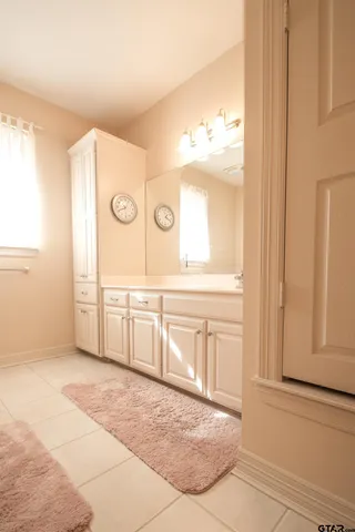 a spacious bathroom with a double vanity sink and a mirror