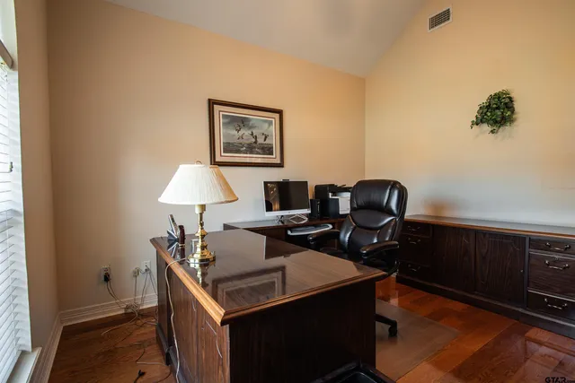 a view of a workspace with furniture and a window