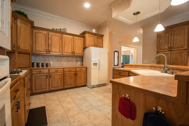 a kitchen with stainless steel appliances granite countertop a sink refrigerator and cabinets
