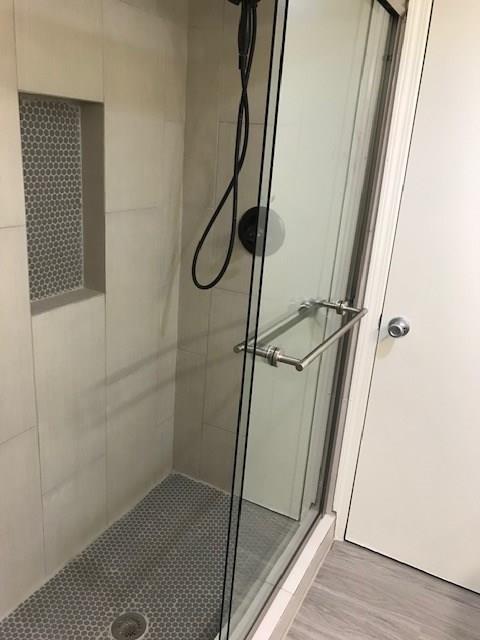 18240 Midway Road, Unit 303 Dallas, TX 75287 - Photo 16 of 22 Full bathroom with a shower stall and light wood-type flooring