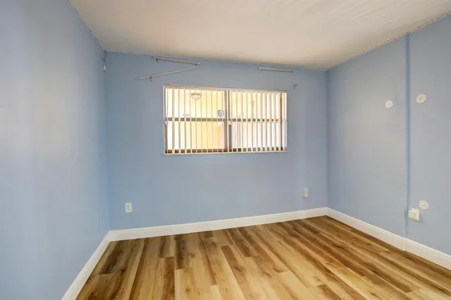 a view of a room with wooden floor and a window