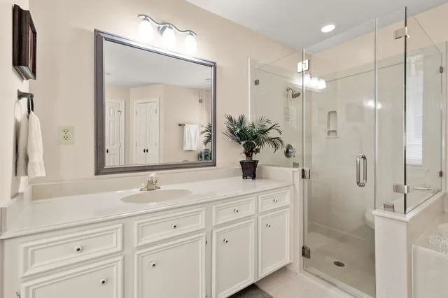 a bathroom with a shower sink double vanity and mirror