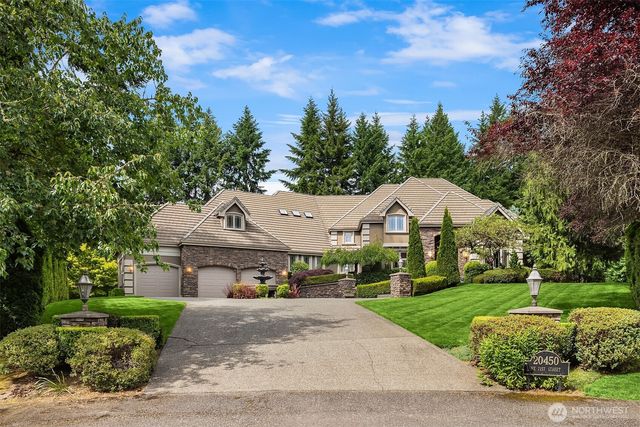 a front view of a house with a yard and trees
