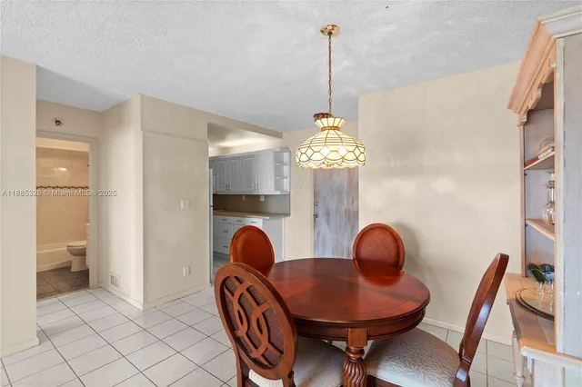 a kitchen with a sink a refrigerator and white cabinets