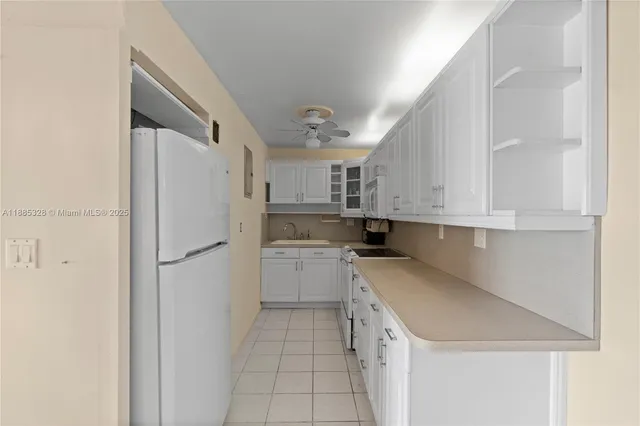 a kitchen with white cabinets and appliances