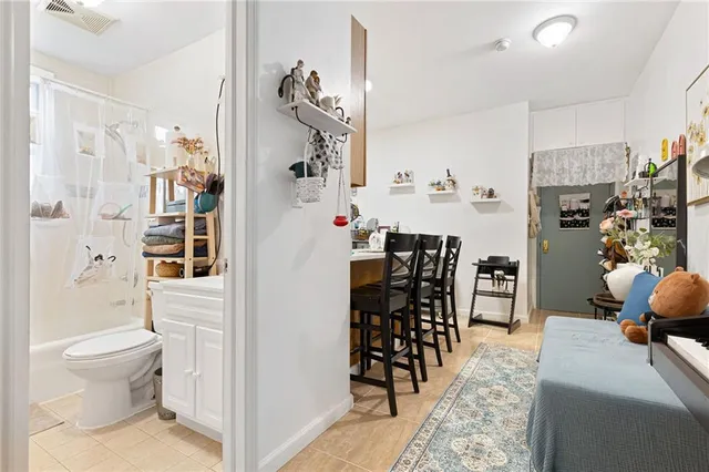 a living room with furniture and a dining table with wooden floor