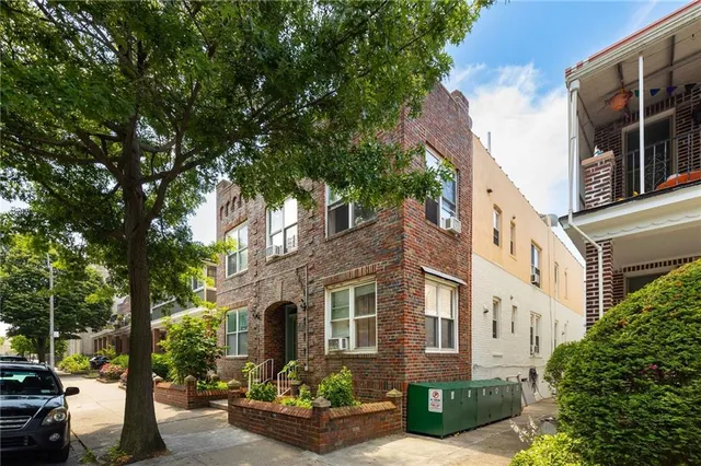 front view of a brick house with a yard