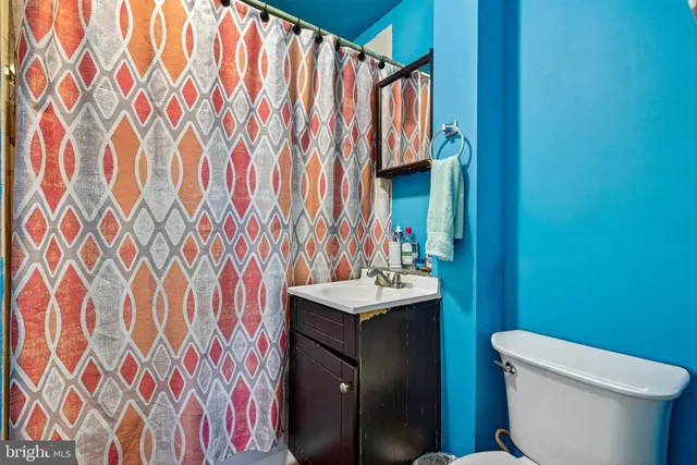 a bathroom with a sink toilet and shower curtain